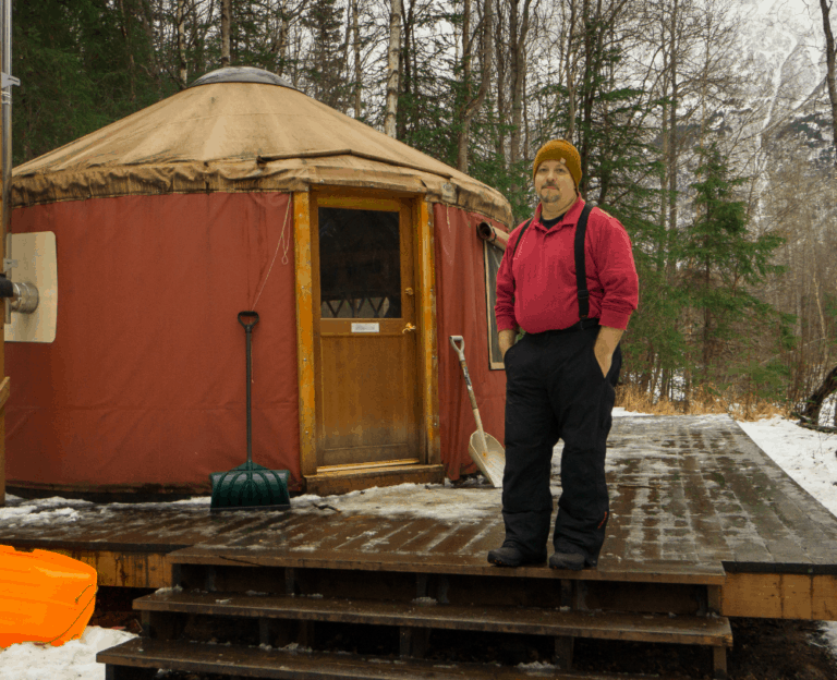 mark standing in front of yurt